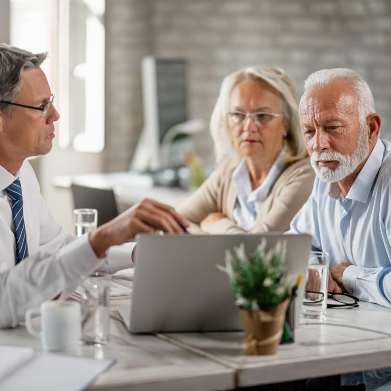 mature-couple-their-bank-manager-using-computer-while-having-consultations-office (1)